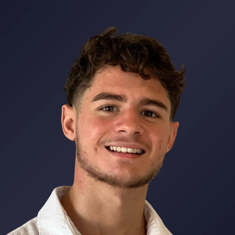 Thiago Cardoso, de camisa branca, sorrindo para a câmera